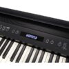 Clavier de piano numérique noir avec écran LCD intégré, affichant les options de morceaux prédéfinis et commandes tactiles.