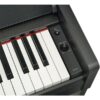 Clavier de piano numérique noir avec boutons de contrôle du volume et de mise en marche sur le panneau latéral.
