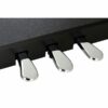 Pédales de piano numériques noires et argentées alignées sous un clavier en bois sombre, capturées en gros plan.