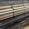 Mécanisme interne d'un piano droit montrant marteaux, cordes et étouffoirs pour une meilleure compréhension de son fonctionnement.