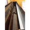 Intérieur d'un piano droit montrant les cordes et marteaux en gros plan, mettant en valeur le mécanisme complexe.