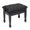 Tabouret de piano noir rembourré réglable avec finition capitonnée et pieds sculptés élégants.