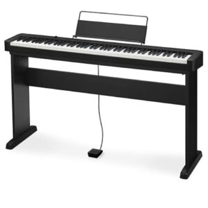 Un piano numérique noir avec support, pédale et porte-partition, posé sur une surface blanche. Aucune personne, monument ou bâtiment visible.