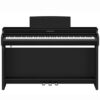 Un piano numérique Yamaha noir avec trois pédales situé dans une pièce bien éclairée. Il est en excellent état et prêt à être joué.