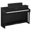 Un piano Yamaha noir à clavier complet est posé sur un sol en bois. Il a trois pédales et un support à partitions.