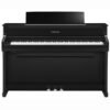 Un piano droit Yamaha noir avec trois pédales, vu de face, posé contre un fond blanc neutre.