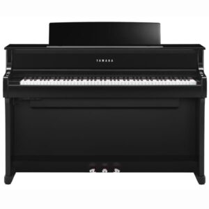 Un piano droit Yamaha noir avec trois pédales, vu de face, posé contre un fond blanc neutre.